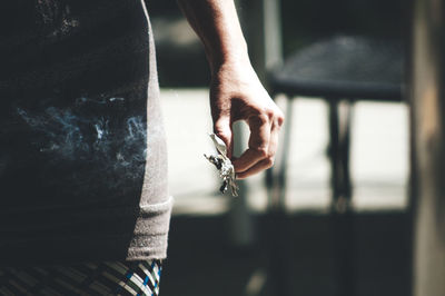 Midsection of woman holding leaves while standing outdoors