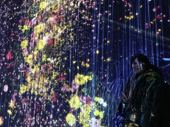 Man looking at illuminated window
