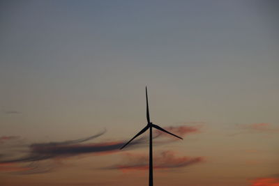 Low angle view of silhouette wind turbine against sky during sunset