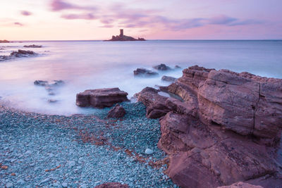 Scenic view of sea and island against sky during sunset