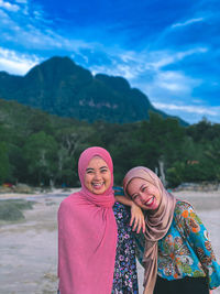 Portrait of smiling young woman against mountains