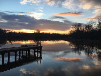 Reflection of trees in water at sunset