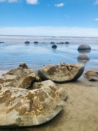 Rocks on beach against sky