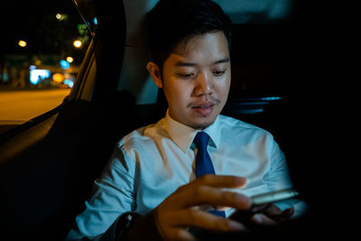 Portrait of man using mobile phone while sitting in car