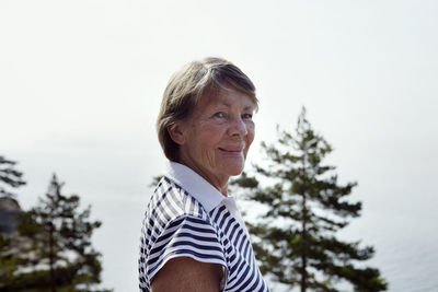 Portrait of smiling woman against sky