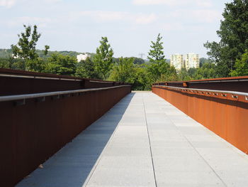 Footpath amidst buildings against sky