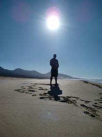 Man standing on sand against clear sky