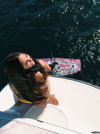 High angle view of young woman sitting on boat