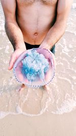 High angle view of man holding water on beach