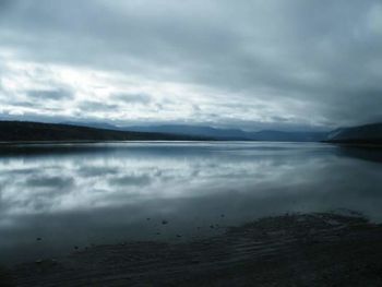 Scenic view of calm lake against cloudy sky