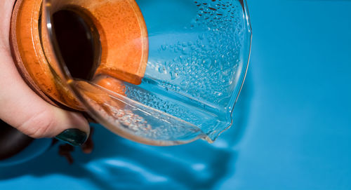 Close-up of hand holding glass of water