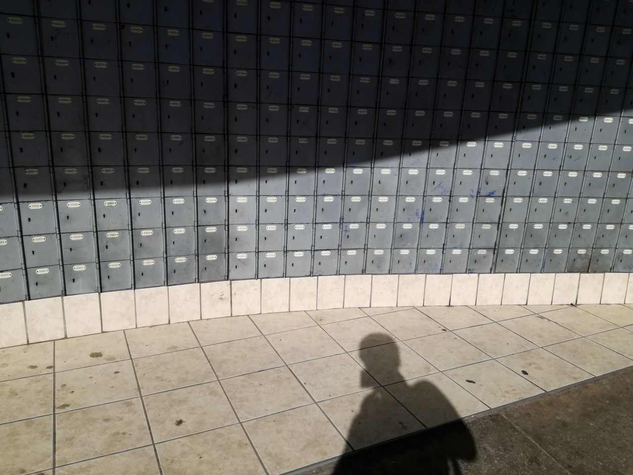 SHADOW OF PERSON ON TILED FLOOR