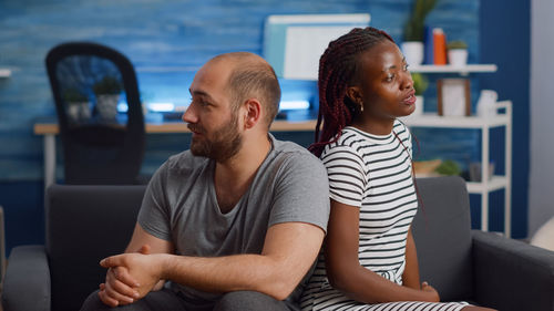 Portrait of smiling friends sitting at home