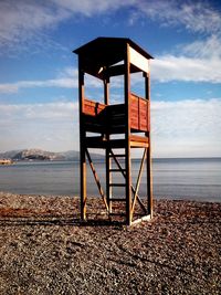 Lifeguard hut on beach against sky