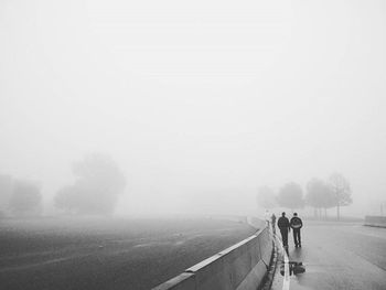 Woman standing on road in foggy weather