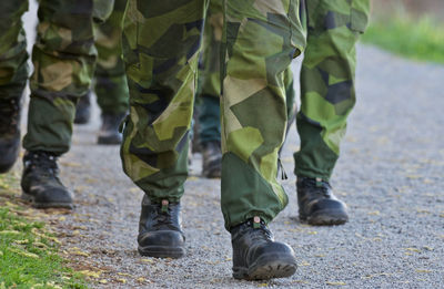 Low section of army soldiers walking on road