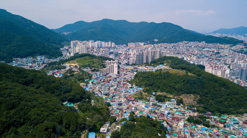 High angle view of cityscape and mountains against sky