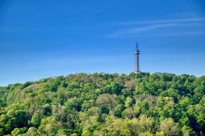 Low angle view of trees and tower against sky