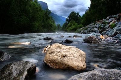 River flowing amidst rocks against sky