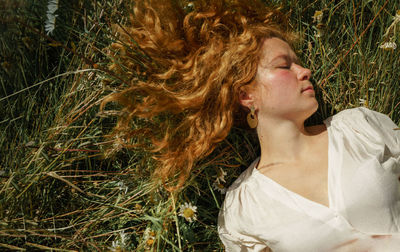 Portrait of young woman lying down plants
