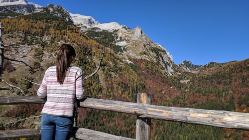 Rear view of woman on mountain against clear sky