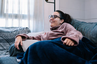 Portrait of young woman sitting on sofa at home