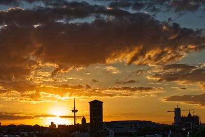 Silhouette buildings against sky during sunset