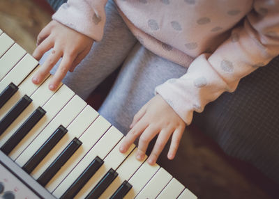 A little girl plays the electric piano.