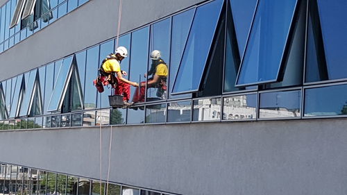 Low angle view of people working on building
