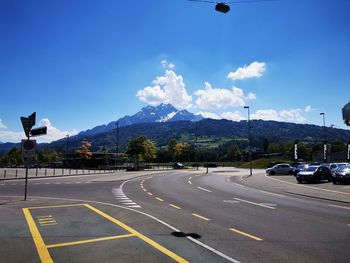 Road by mountains against sky