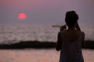 Rear view of woman standing on beach