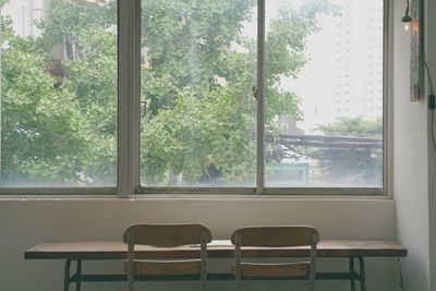 Empty chairs by window in summer