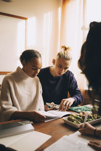 Young couple looking down while sitting on table