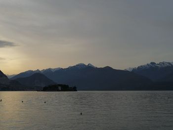 Scenic view of lake by mountains against sky