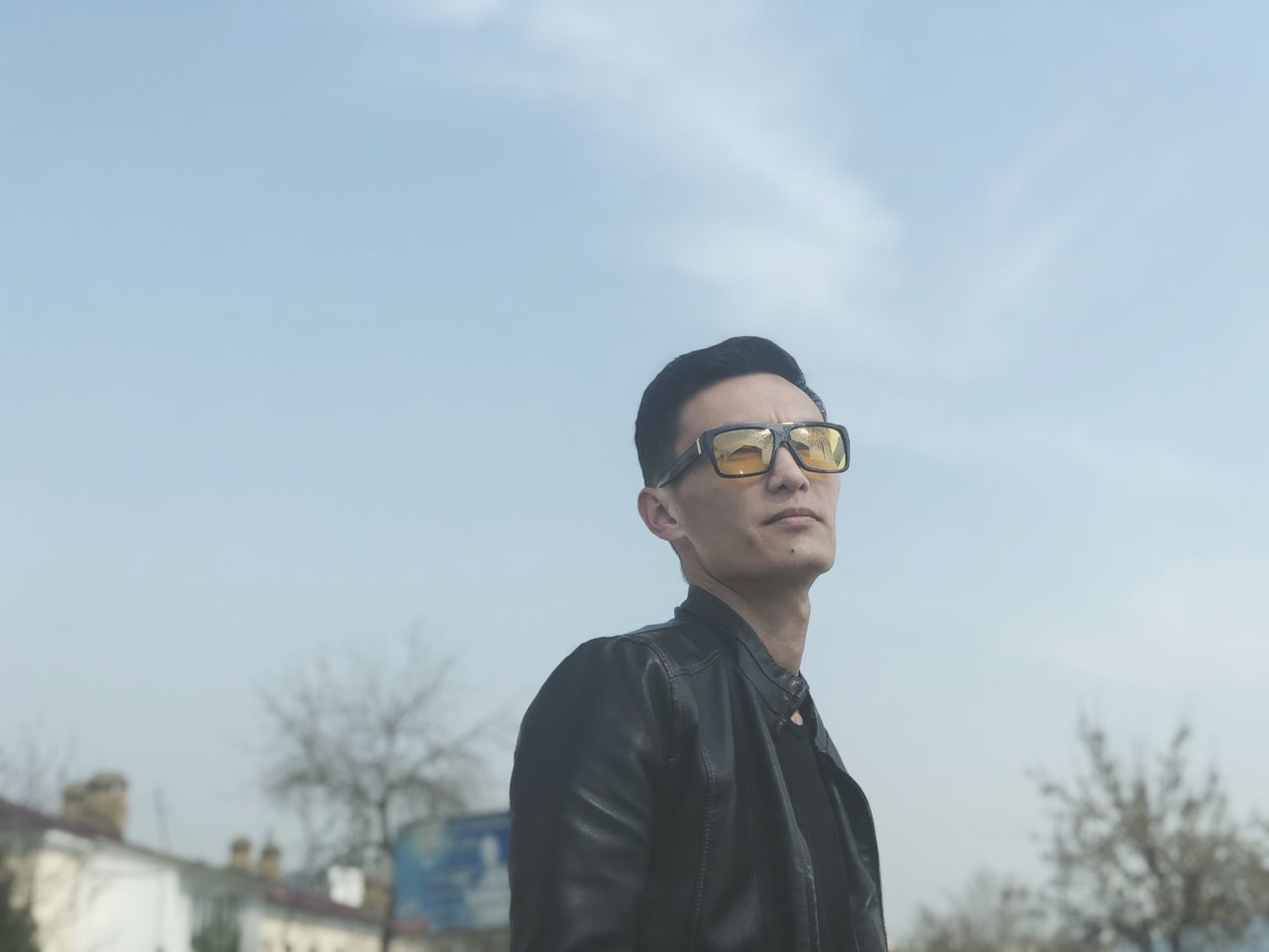 PORTRAIT OF YOUNG MAN STANDING IN FRONT OF SKY