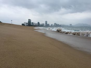 Scenic view of beach against sky in city