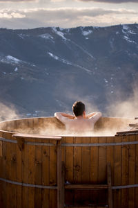 Adult man relaxes in barrel with hot water, in winter, transylva