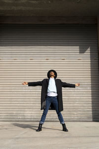 Full length of man standing against wall