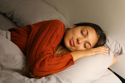 Young woman sleeping on bed at home