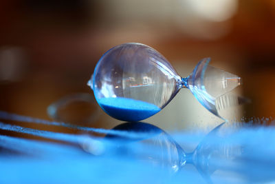 Close-up of broken hourglass on table