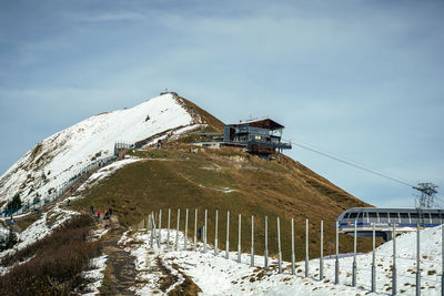 Traditional windmill on snowcapped mountain against sky