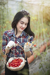 Young woman holding fruits in garden