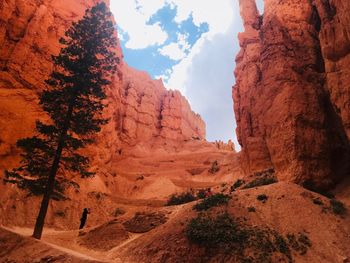 Person standing amidst rock formations at desert