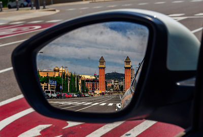 Reflection of buildings on side-view mirror