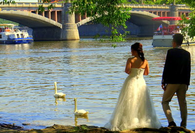 Couple kissing on bridge over water