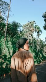 
rear view of woman standing among the trees