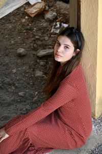 Portrait of young woman against wall