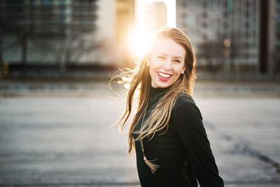 Portrait of smiling young woman standing outdoors