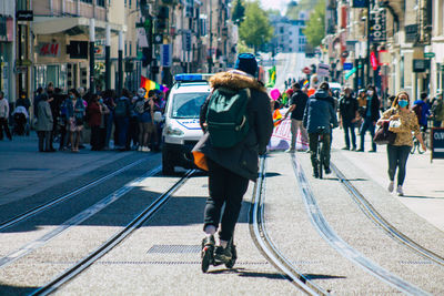 Rear view of people walking on city street