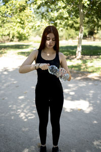 Sportsman with bottle of water outdoors in a public park.